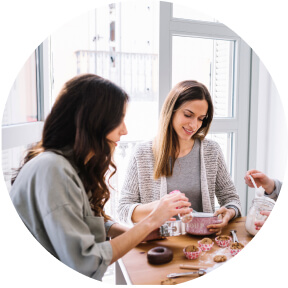 Two young ledies are eating donuts